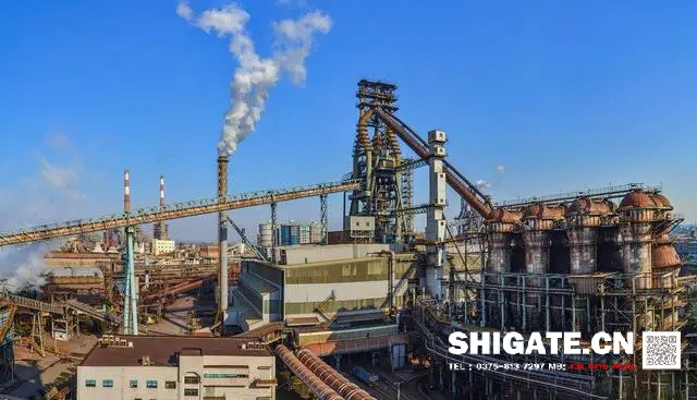 煉鐵過程實質(zhì)上是將鐵從其自然形態(tài)——礦石等含鐵化合物中還原出來的過程。煉鐵方法主要有高爐法、直接還原法、熔融還原法等,其原理是礦石在特定的氣氛中(還原物質(zhì)CO、H2、C;適宜溫度等)通過物化反應(yīng)獲取還原后的生鐵。生鐵除了少部分用于鑄造外,絕大部分是作為煉鋼原料。 高爐煉鐵是現(xiàn)代煉鐵的主要方法,鋼鐵生產(chǎn)中的重要環(huán)節(jié)。這種方法是由古代豎爐煉鐵發(fā)展、改進(jìn)而成的。盡管世界各國研究發(fā)展了很多新的煉鐵法,但由于高爐煉鐵技術(shù)經(jīng)濟(jì)指標(biāo)良好,工藝簡單,生產(chǎn)量大,勞動生產(chǎn)率高,能耗低,這種方法生產(chǎn)的鐵仍占世界鐵總產(chǎn)量的95%以上。 煉鐵工藝是是將含鐵原料(燒結(jié)礦、球團(tuán)礦或鐵礦)、燃料(焦炭、煤粉等)及其它輔助原料(石灰石、白云石、錳礦等)按一定比例自高爐爐頂裝入高爐,并由熱風(fēng)爐在高爐下部沿爐周的風(fēng)口向高爐內(nèi)鼓入熱風(fēng)助焦炭燃燒(有的高爐也噴吹煤粉、重油、天然氣等輔助燃料),在高溫下焦炭中的碳同鼓入空氣中的氧燃燒生成的一氧化碳和氫氣。 原料、燃料隨著爐內(nèi)熔煉等過程的進(jìn)行而下降,在爐料下降和上升的煤氣相遇,先后發(fā)生傳熱、還原、熔化、脫炭作用而生成生鐵,鐵礦石原料中的雜質(zhì)與加入爐內(nèi)的熔劑相結(jié)合而成渣,爐底鐵水間斷地放出裝入鐵水罐,送往煉鋼廠。同時產(chǎn)生高爐煤氣,爐渣兩種副產(chǎn)品,高爐渣鐵主要礦石中不還原的雜質(zhì)和石灰石等熔劑結(jié)合生成,自渣口排出后,經(jīng)水淬處理后全部作為水泥生產(chǎn)原料;產(chǎn)生的煤氣從爐頂導(dǎo)出,經(jīng)除塵后,作為熱風(fēng)爐、加熱爐、焦?fàn)t、鍋爐等的燃料。 煉鐵過程實質(zhì)上是將鐵從其自然形態(tài)——礦石等含鐵化合物中還原出來的過程。煉鐵方法主要有高爐法、直接還原法、熔融還原法等,其原理是礦石在特定的氣氛中(還原物質(zhì)CO、H2、C;適宜溫度等)通過物化反應(yīng)獲取還原后的生鐵。生鐵除了少部分用于鑄造外,絕大部分是作為煉鋼原料。 高爐煉鐵是現(xiàn)代煉鐵的主要方法,鋼鐵生產(chǎn)中的重要環(huán)節(jié)。這種方法是由古代豎爐煉鐵發(fā)展、改進(jìn)而成的。盡管世界各國研究發(fā)展了很多新的煉鐵法,但由于高爐煉鐵技術(shù)經(jīng)濟(jì)指標(biāo)良好,工藝簡單,生產(chǎn)量大,勞動生產(chǎn)率高,能耗低,這種方法生產(chǎn)的鐵仍占世界鐵總產(chǎn)量的95%以上。 煉鐵工藝是是將含鐵原料(燒結(jié)礦、球團(tuán)礦或鐵礦)、燃料(焦炭、煤粉等)及其它輔助原料(石灰石、白云石、錳礦等)按一定比例自高爐爐頂裝入高爐,并由熱風(fēng)爐在高爐下部沿爐周的風(fēng)口向高爐內(nèi)鼓入熱風(fēng)助焦炭燃燒(有的高爐也噴吹煤粉、重油、天然氣等輔助燃料),在高溫下焦炭中的碳同鼓入空氣中的氧燃燒生成的一氧化碳和氫氣。 原料、燃料隨著爐內(nèi)熔煉等過程的進(jìn)行而下降,在爐料下降和上升的煤氣相遇,先后發(fā)生傳熱、還原、熔化、脫炭作用而生成生鐵,鐵礦石原料中的雜質(zhì)與加入爐內(nèi)的熔劑相結(jié)合而成渣,爐底鐵水間斷地放出裝入鐵水罐,送往煉鋼廠。同時產(chǎn)生高爐煤氣,爐渣兩種副產(chǎn)品,高爐渣鐵主要礦石中不還原的雜質(zhì)和石灰石等熔劑結(jié)合生成,自渣口排出后,經(jīng)水淬處理后全部作為水泥生產(chǎn)原料;產(chǎn)生的煤氣從爐頂導(dǎo)出,經(jīng)除塵后,作為熱風(fēng)爐、加熱爐、焦?fàn)t、鍋爐等的燃料。